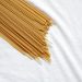 Spaghetti crudi messi in diagonale su sfondo bianco